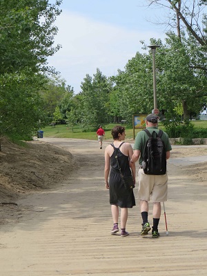 Walk-a-thon participant and sighted guide walking along the boardwalk. 