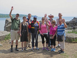 Members and volunteers posing on a beach in summertime.