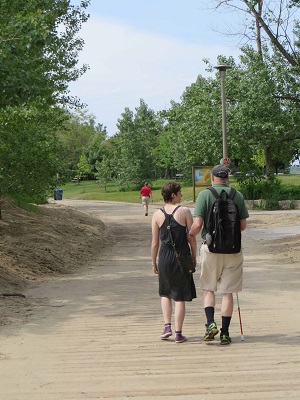 Walk-a-thon participant and sighted guide walking along the boardwalk.